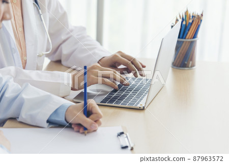 Close up hands of two women doctor medical lab discussing together healthcare teamwork. Two asian women hand doctors meeting write prescription medical clinic. Doctor discuss using laptop write note Close up hands of two women doctor medical lab discussing together healthcare teamwork. Two asian women hand doctors meeting write prescription medical clinic. Doctor discuss using laptop write note 87963572