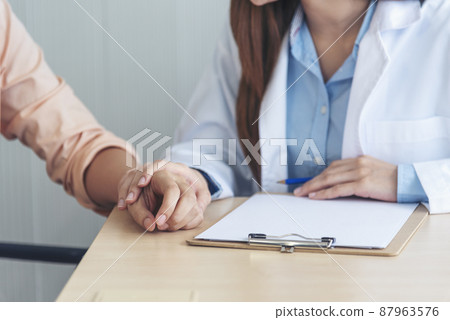 Close up hands Woman doctor holding hands patient encourage cheer up consultation at hospital medicare clinic. Doctor talking to patient support giving hope mental health therapy consoling recovery 87963576