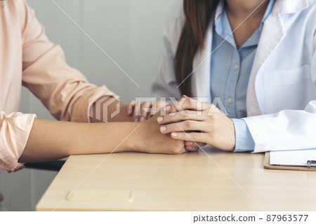 Close up hands Woman doctor holding hands patient encourage cheer up consultation at hospital medicare clinic. Doctor talking to patient support giving hope mental health therapy consoling recovery Close up hands Woman doctor holding hands patient encourage cheer up consultation at hospital medicare clinic. Doctor talking to patient support giving hope mental health therapy consoling recovery 87963577