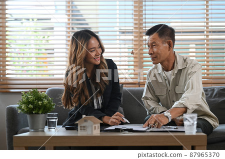 Elderly man meeting with financial advisor and discussing future property purchase contract terms. Elderly man meeting with financial advisor and discussing future property purchase contract terms. 87965370
