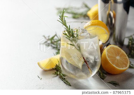 Refreshing drink with natural ice, lemon, and rosemary. 87965375