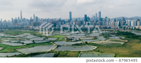 Aerial view of rural green fields with fish ponds on Hong Kong and the skylines of Shenzhen Aerial view of rural green fields with fish ponds on Hong Kong and the skylines of Shenzhen 87965495