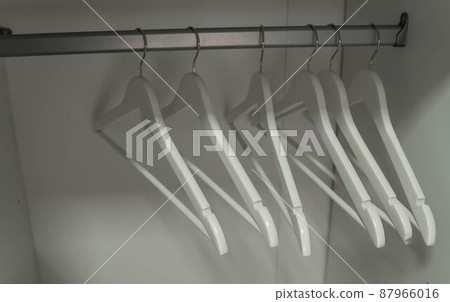 Wooden hangers. Close up of white hangers. Clothes on a rail Wooden hangers. Close up of white hangers. Clothes on a rail 87966016
