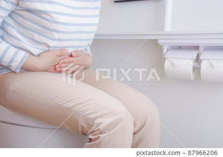 Woman sitting on the toilet seat 87966206