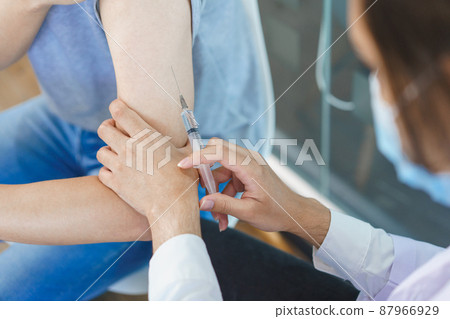 Vaccination concept, Male doctor in face mask injecting vaccine against covid-19 for male patient 87966929