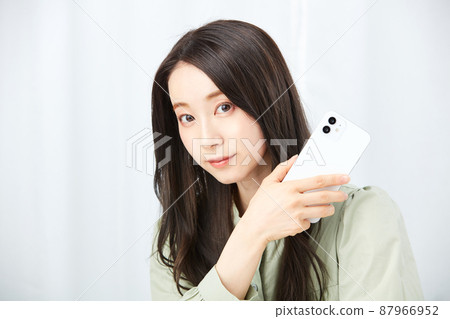 Woman holding a smartphone Woman holding a smartphone 87966952