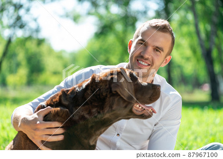 Young man with a dog in the park 87967100