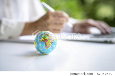 World globe with businesswoman and computer laptop at the background. World globe with businesswoman and computer laptop at the background. 87967649