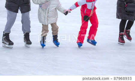feet of different people skating on the ice rink feet of different people skating on the ice rink 87968933