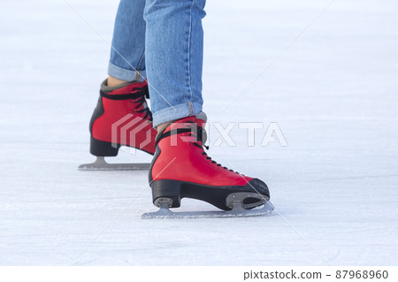 legs of a woman ice skating on an ice rink. hobbies and leisure. winter sports legs of a woman ice skating on an ice rink. hobbies and leisure. winter sports 87968960