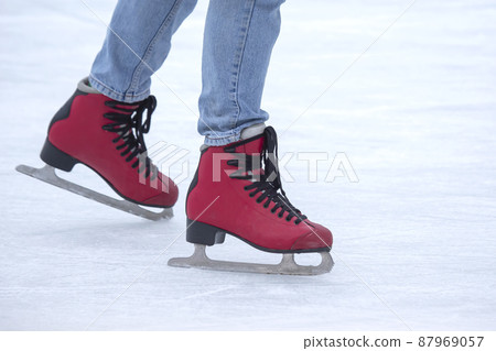 Ice skating on an ice rink. legs with skates. Winter active sport and leisure hobby. 87969057