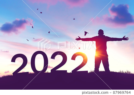 Man raise hand up on sunset sky with birds flying at top of mountain and number like 2022 abstract background. Happy new year and holiday concept. Man raise hand up on sunset sky with birds flying at top of mountain and number like 2022 abstract background. Happy new year and holiday concept. 87969764