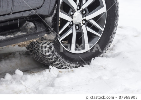 passenger car drives on a snowy road passenger car drives on a snowy road 87969905