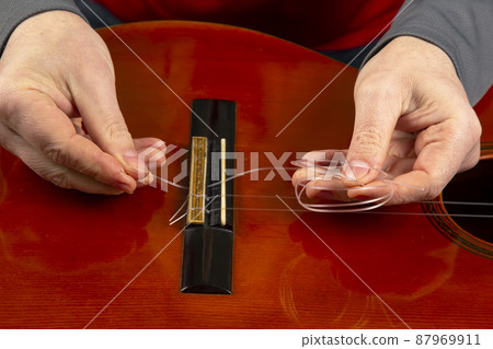 replacement and insertion of nylon strings in a classical guitar. lesson for a musician replacement and insertion of nylon strings in a classical guitar. lesson for a musician 87969911