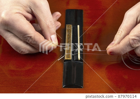 replacement and insertion of nylon strings in a classical guitar. lesson for a musician replacement and insertion of nylon strings in a classical guitar. lesson for a musician 87970114