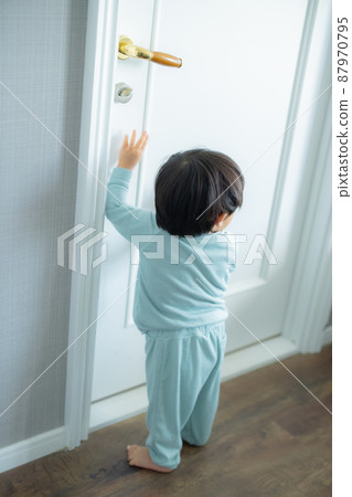 1 year old child trying to open the door 87970795