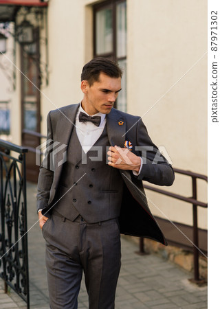 Portrait of an attractive young businessman in urban background wearing suit and a tie. 87971302