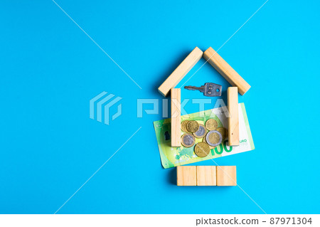 Wooden toy house with keys on blue. Empty space to put text or something else. 87971304