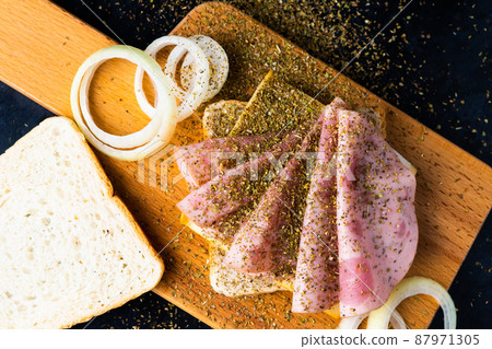 Slices of sausage Mortadella and onion on cutting board Slices of sausage Mortadella and onion on cutting board 87971305