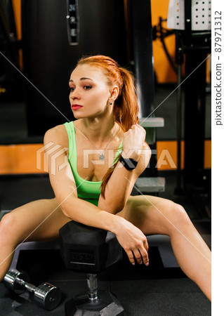 Beautiful muscular fit woman exercising and building muscles Beautiful muscular fit woman exercising and building muscles 87971312