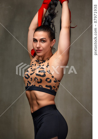 Attractive Young Woman Standing Strong In The Gym And Flexing Muscles - Beautiful Athletic Fitness Model Posing After Exercises. 87971938