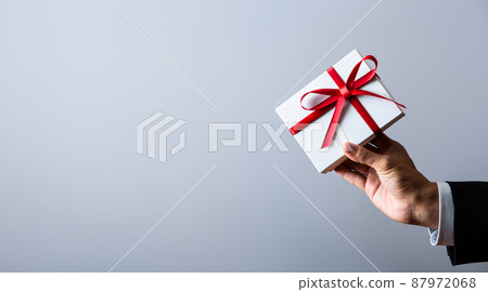 Hand of a businessman with a gift Hand of a businessman with a gift 87972068