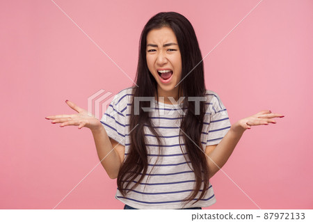 What do you want, Portrait of enraged irritated girl with brunette hair raising hands in questioning gesture, scolding and screaming, having conflict. indoor studio shot isolated on pink background What do you want, Portrait of enraged irritated girl with brunette hair raising hands in questioning gesture, scolding and screaming, having conflict. indoor studio shot isolated on pink background 87972133