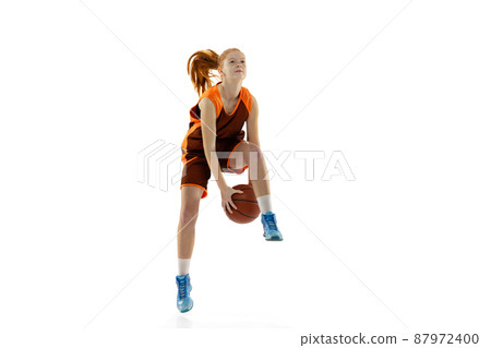 Portrait of young active girl, basketball player in motion, dribblig ball in a jump isolated over white studio background Portrait of young active girl, basketball player in motion, dribblig ball in a jump isolated over white studio background 87972400