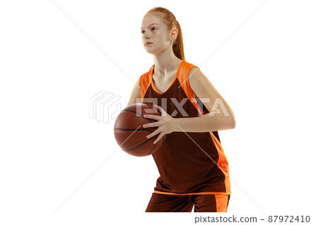 Half-length portrait of young sportive girl, basketball player training, preparing to throw a ball isolated over white studio background Half-length portrait of young sportive girl, basketball player training, preparing to throw a ball isolated over white studio background 87972410