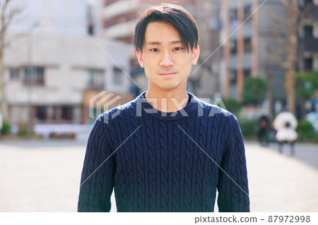 Handsome Japanese man smiling at the camera 87972998