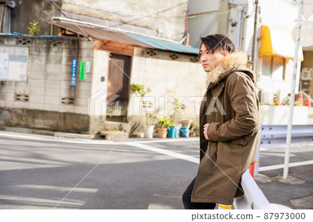 Japanese man leaning on a guardrail 87973000