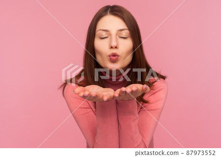 Beautiful tender brunette woman sending air kisses to camera, love and affection, saint valentines day celebration. Indoor studio shot isolated on pink background Beautiful tender brunette woman sending air kisses to camera, love and affection, saint valentines day celebration. Indoor studio shot isolated on pink background 87973552