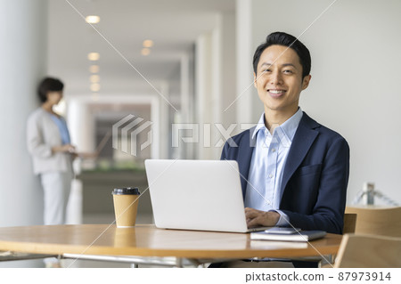 Office work image: A businessman with a smile looking at the camera 87973914