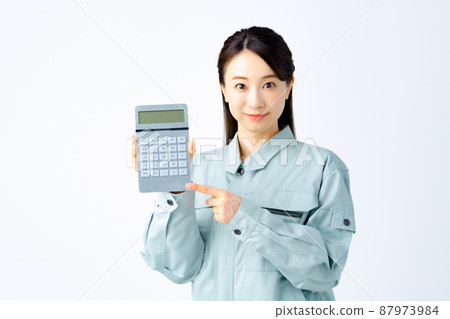A young business woman with a calculator in work clothes 87973984