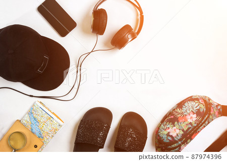 Travel accessories set on white background: smart, headphones, cap, map and bag. Top view point. Sun flare 87974396