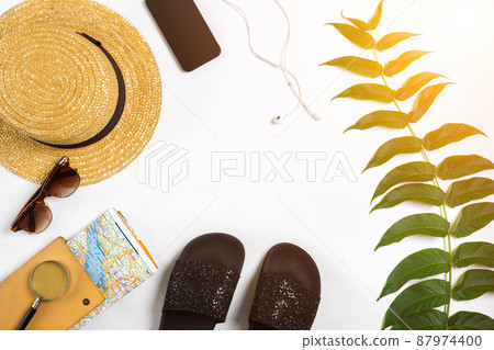 Travel accessories set on white background: smart, headphones, hat, map and sunglasses. Top view point. Sun flare Travel accessories set on white background: smart, headphones, hat, map and sunglasses. Top view point. Sun flare 87974400