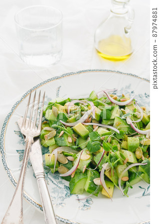 Green vegetarian salad of avocado, cucumber, seeds, micro-greens and red onion on a white background 87974881
