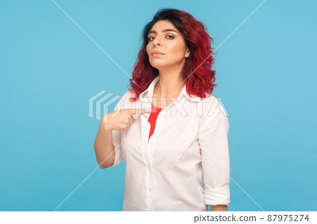 I'm the best. Portrait of egoistic hipster woman with fancy red hair pointing herself, looking with arrogance, feeling confident and self-important. indoor studio shot isolated on blue background 87975274