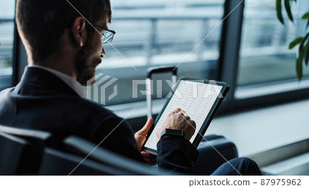 businessman works on a digital tablet on a business trip. businessman works on a digital tablet on a business trip. 87975962
