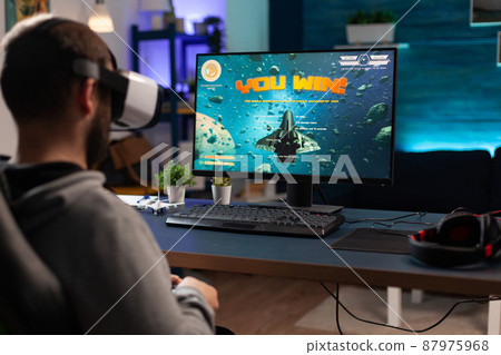 Gamer using vr glasses and controller to play video games. Man with virtual  reality goggles holding joystick in front of computer, playing online game.  Player having fun with games Stock Photo 