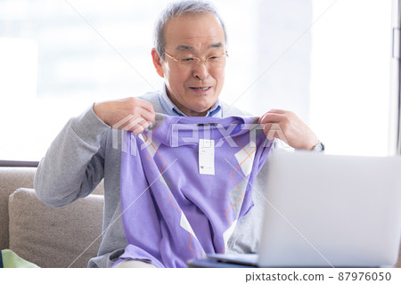 視頻通話：一位老人打開了寄給他的禮物，他的家人在線連接。 87976050