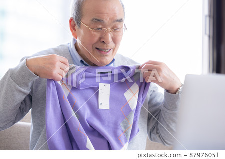 視頻通話：一位老人打開了寄給他的禮物，他的家人在線連接。 87976051