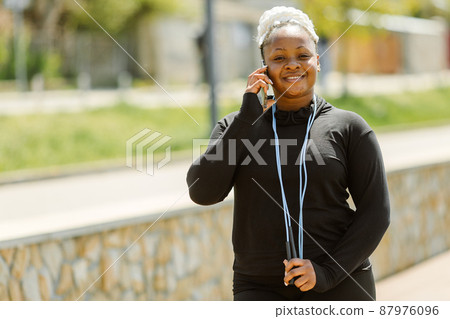Afro-american plus size woman doing workout exercises session outdoor Afro-american plus size woman doing workout exercises session outdoor 87976096