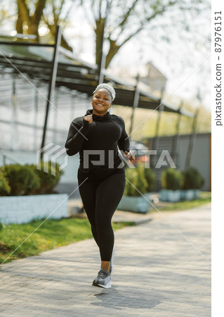 Afro-american plus size woman jogging outdoor 87976151
