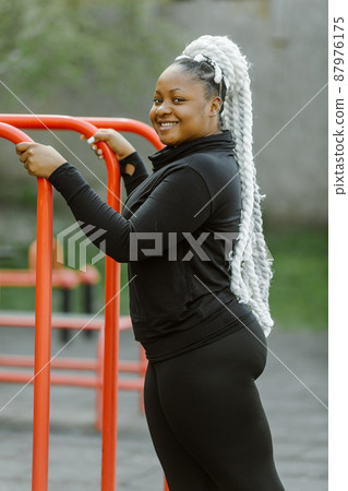Afro-american plus size woman doing workout exercises session outdoor Afro-american plus size woman doing workout exercises session outdoor 87976175