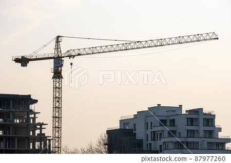 Tower cranes and high residential apartment buildings under construction. Real estate development. 87977260