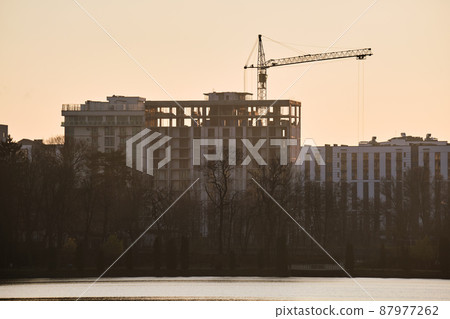 Tower crane at high residential apartment buildings construction site. Real estate development Tower crane at high residential apartment buildings construction site. Real estate development 87977262