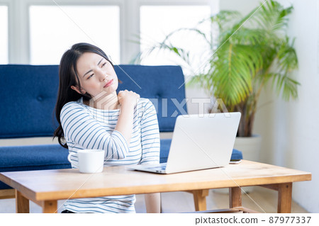 因遠程辦公而肩膀僵硬的年輕女性 87977337