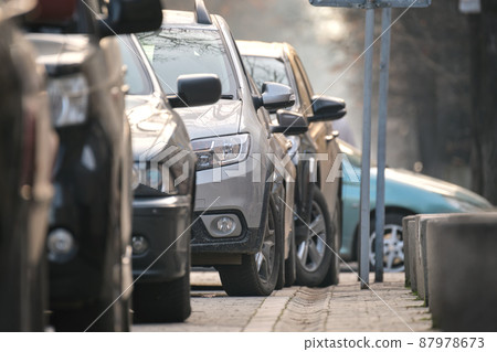 City traffic with cars parked in line on street side City traffic with cars parked in line on street side 87978673