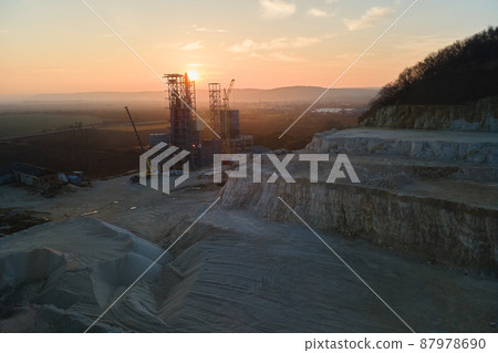 Cement factory at open pit mining of construction sand stone materials. Digging of gravel resources at quarry at sunset Cement factory at open pit mining of construction sand stone materials. Digging of gravel resources at quarry at sunset 87978690